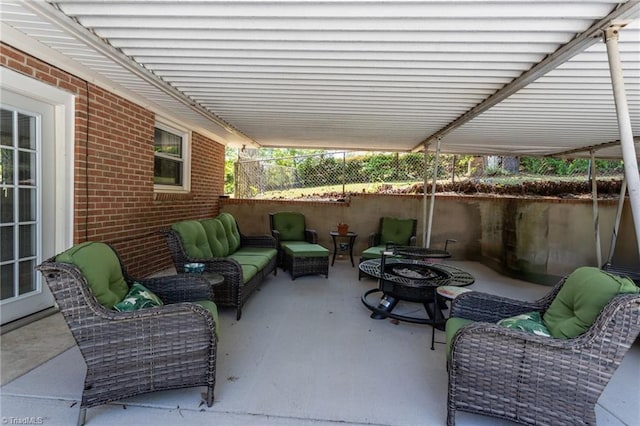 view of patio with an outdoor living space with a fire pit and fence