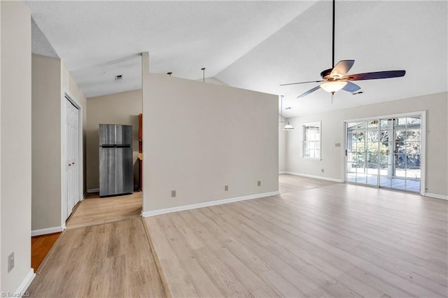 unfurnished living room featuring lofted ceiling, a ceiling fan, a textured ceiling, light wood-style floors, and baseboards