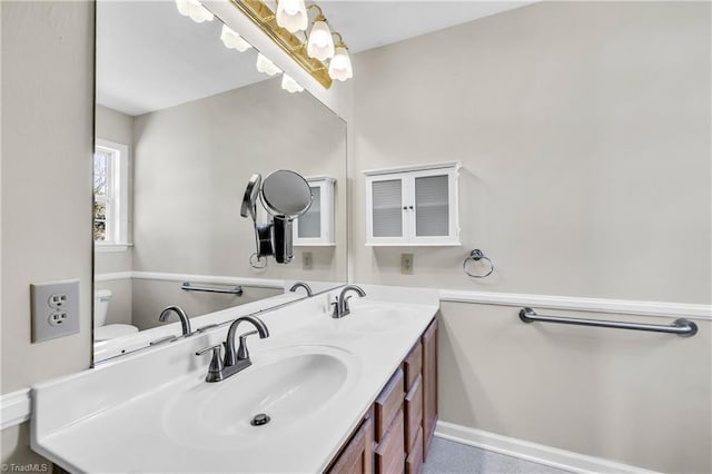 bathroom featuring a sink, baseboards, and double vanity