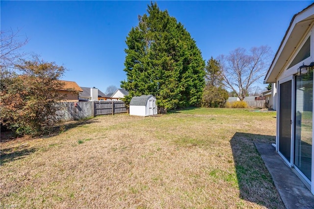 view of yard featuring a storage shed, an outbuilding, and a fenced backyard