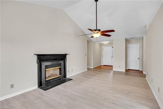 unfurnished living room featuring lofted ceiling, a glass covered fireplace, light wood finished floors, baseboards, and ceiling fan