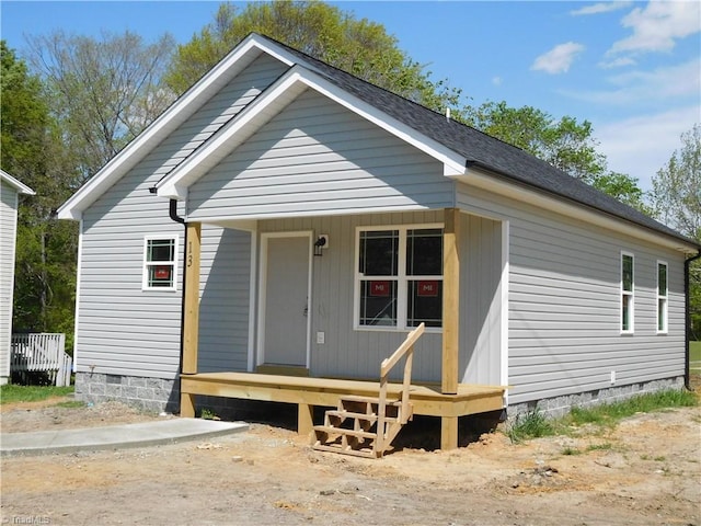 view of front of home featuring covered porch, crawl space, and roof with shingles