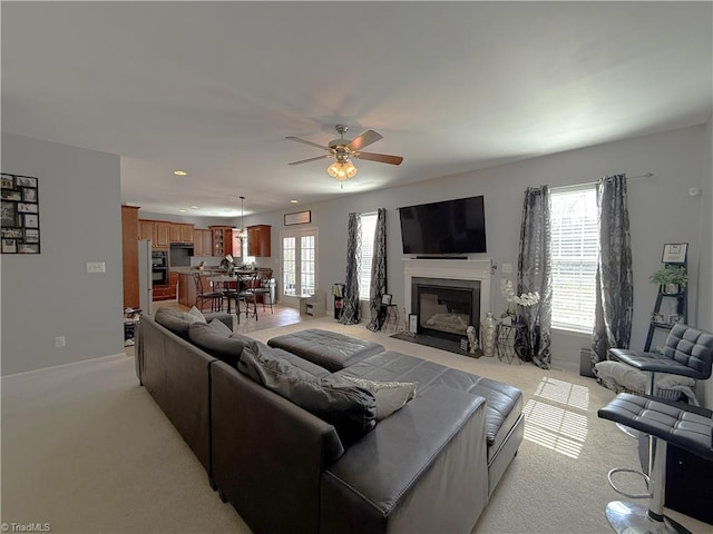 living area with recessed lighting, a fireplace with flush hearth, light carpet, ceiling fan, and baseboards