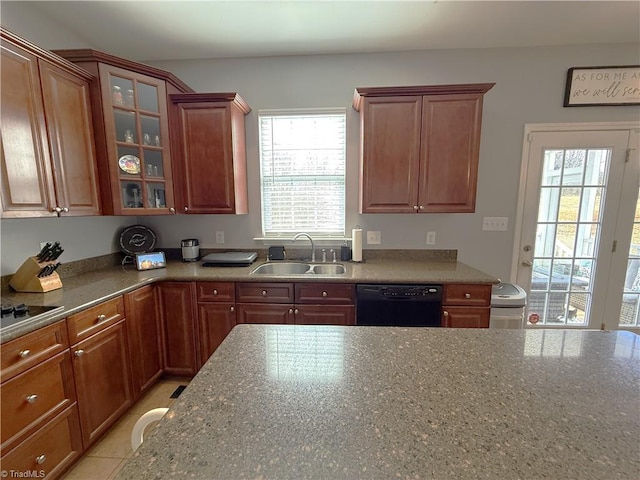 kitchen featuring black dishwasher, glass insert cabinets, a sink, and a wealth of natural light