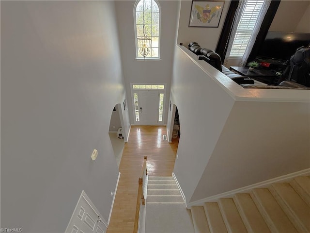 foyer entrance with light wood-type flooring, a high ceiling, and stairway