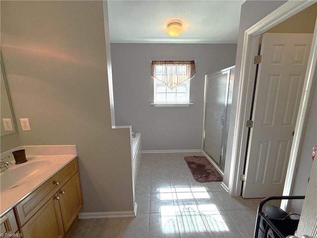 bathroom with baseboards, a shower stall, vanity, and tile patterned floors