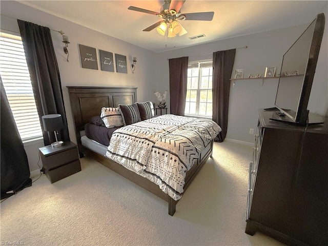 bedroom featuring light carpet, ceiling fan, visible vents, and baseboards