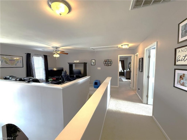 interior space with attic access, baseboards, visible vents, a ceiling fan, and carpet flooring