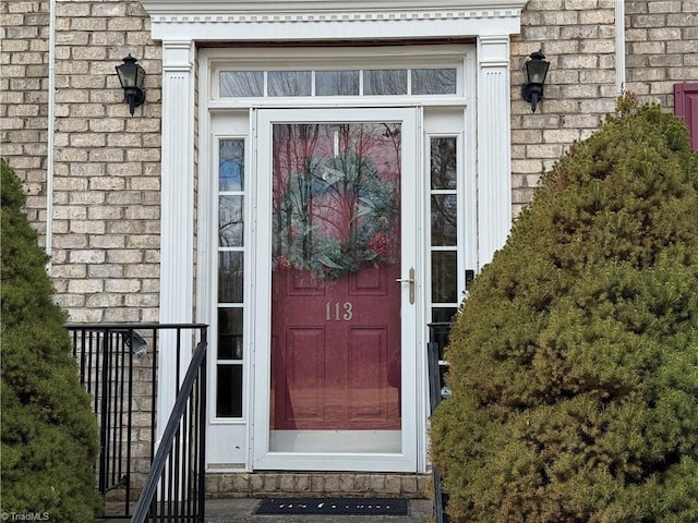 doorway to property featuring brick siding