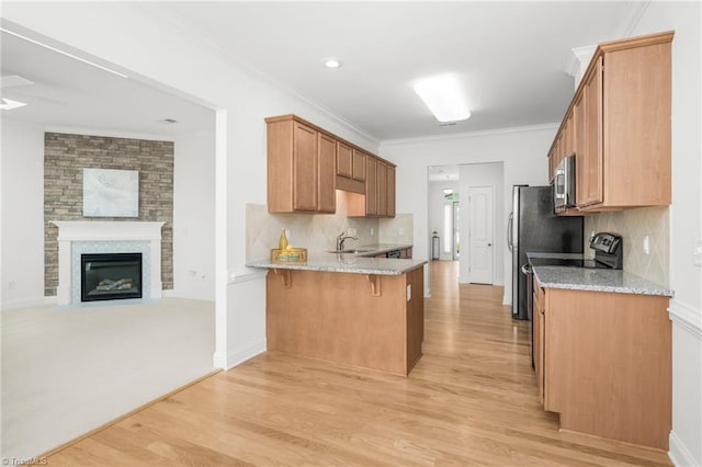6924 Langdon Village Ct, Clemmons, NC 27012 - kitchen with open floor plan, appliances with stainless steel finishes, a peninsula, light wood finished floors, and crown molding