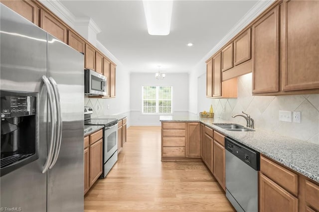 6924 Langdon Village Ct, Clemmons, NC 27012 - kitchen featuring appliances with stainless steel finishes, light wood-style flooring, brown cabinetry, light stone counters, and decorative backsplash