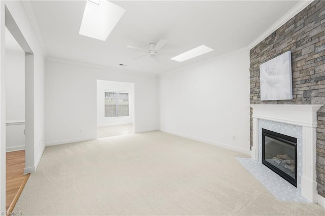 6924 Langdon Village Ct, Clemmons, NC 27012 - unfurnished living room featuring a skylight, ornamental molding, a fireplace with flush hearth, a ceiling fan, and carpet
