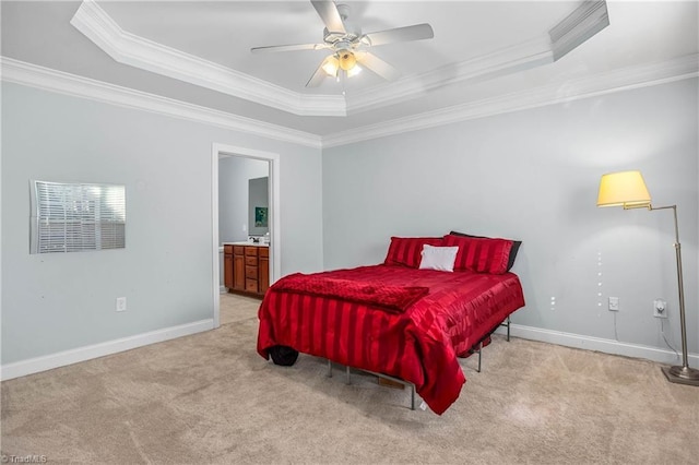 bedroom featuring connected bathroom, crown molding, light carpet, a tray ceiling, and ceiling fan