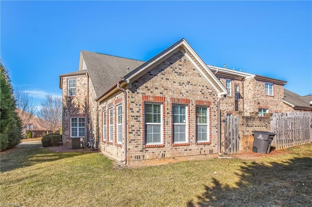 back of property featuring central AC and a lawn