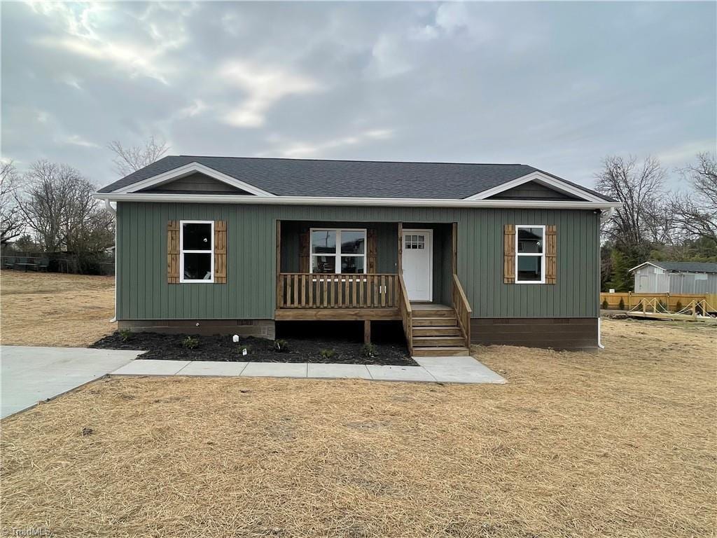 manufactured / mobile home featuring covered porch and a front yard