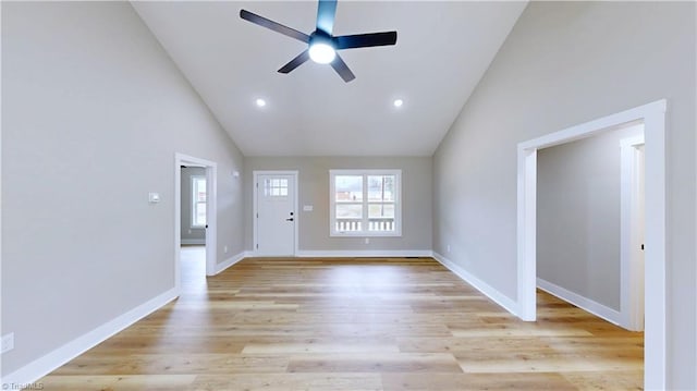 unfurnished living room with high vaulted ceiling, plenty of natural light, and light hardwood / wood-style floors