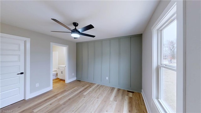 unfurnished bedroom featuring ensuite bathroom, ceiling fan, and light wood-type flooring