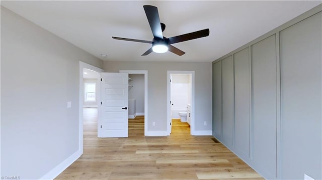 unfurnished bedroom with ceiling fan, ensuite bath, and light hardwood / wood-style floors