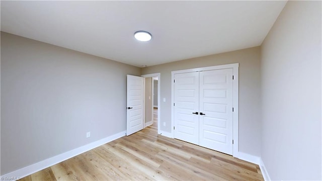 unfurnished bedroom with a closet and light hardwood / wood-style flooring