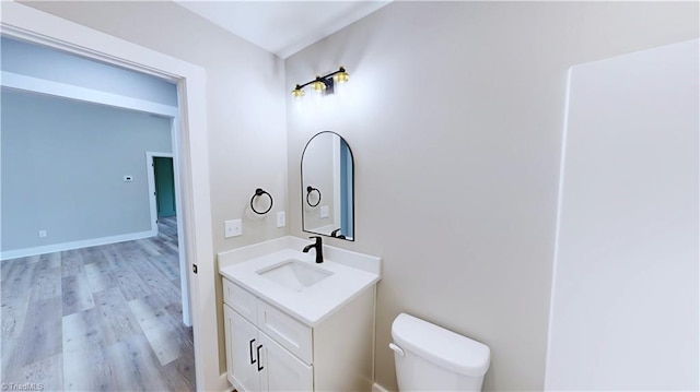 bathroom featuring hardwood / wood-style flooring, vanity, and toilet