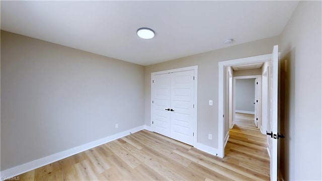 unfurnished bedroom featuring a closet and light hardwood / wood-style flooring