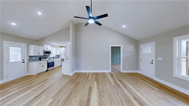 unfurnished living room with ceiling fan, high vaulted ceiling, light hardwood / wood-style floors, and sink