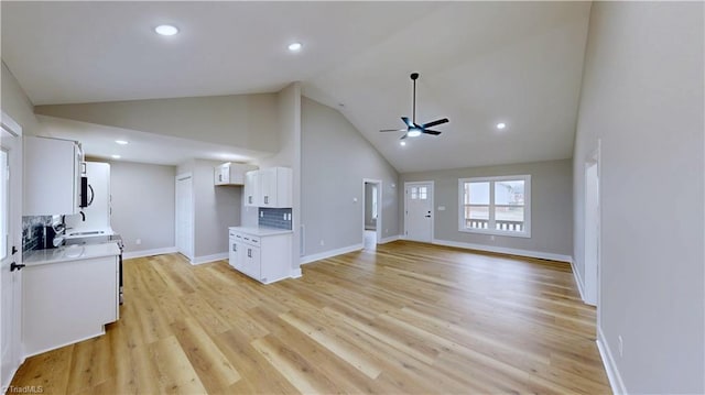 unfurnished living room with light hardwood / wood-style flooring, high vaulted ceiling, and ceiling fan