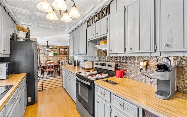 kitchen featuring gray cabinetry, hanging light fixtures, appliances with stainless steel finishes, light hardwood / wood-style floors, and a chandelier