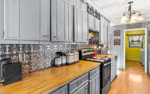 kitchen with stainless steel electric range oven, a chandelier, decorative light fixtures, gray cabinets, and light wood-type flooring