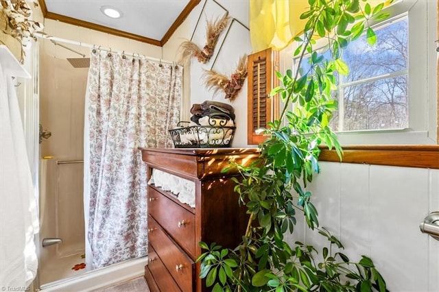 bathroom with a wealth of natural light, crown molding, and walk in shower