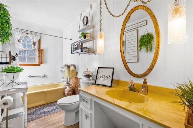 full bathroom with ornamental molding, toilet, shower / washtub combination, vanity, and hardwood / wood-style flooring