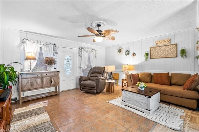 living room featuring a textured ceiling and ceiling fan