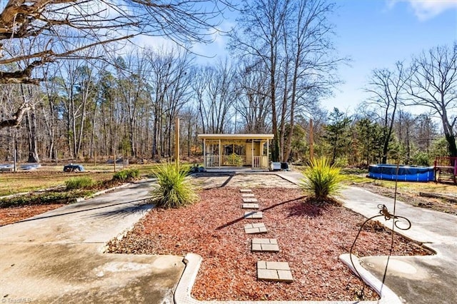 view of yard featuring a porch and a covered pool