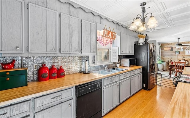 kitchen with gray cabinetry, sink, black dishwasher, stainless steel fridge, and decorative light fixtures