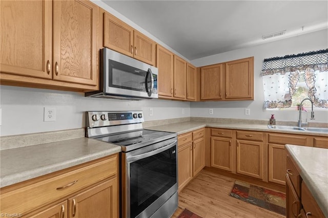119 Tadworth Ct, Mebane, NC 27302 - kitchen featuring stainless steel appliances, light wood-style flooring, and light countertops