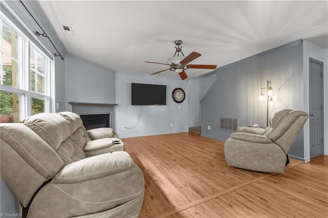 119 Tadworth Ct, Mebane, NC 27302 - living room with a fireplace, light wood-style floors, ornamental molding, and a ceiling fan