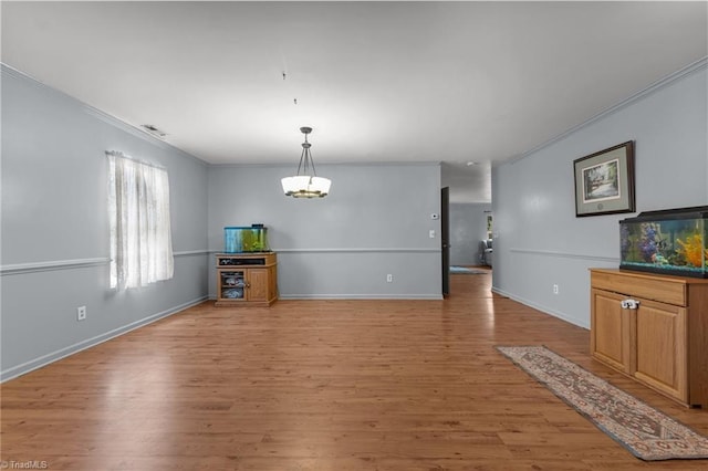 119 Tadworth Ct, Mebane, NC 27302 - unfurnished living room featuring ornamental molding, light wood finished floors, and a chandelier