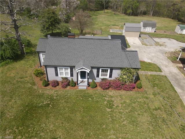 view of front of house with a shingled roof and a front lawn