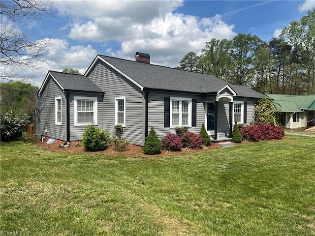view of front facade featuring a front lawn, a shingled roof, and a chimney