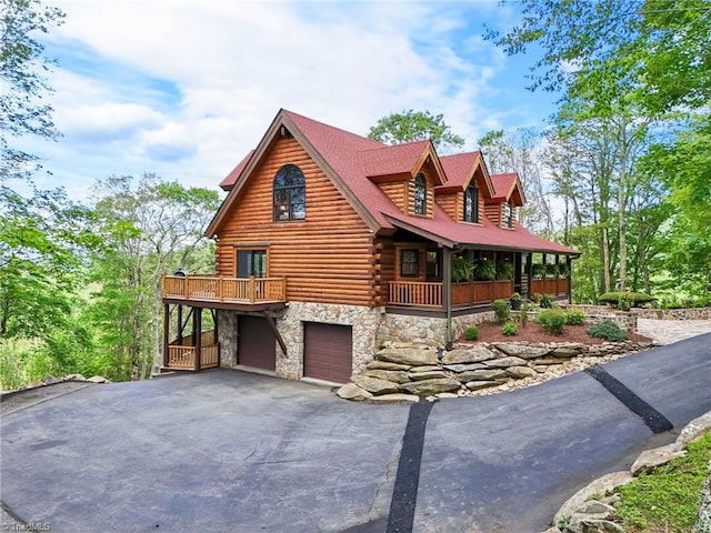 324 Sugar View Trl, Banner Elk, NC 28604 - view of front facade featuring stone siding, log exterior, an attached garage, and driveway