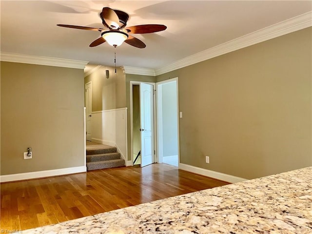 unfurnished bedroom featuring crown molding, wood finished floors, and baseboards