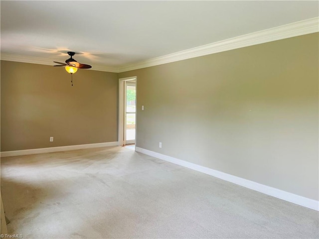 spare room with baseboards, ornamental molding, a ceiling fan, and light colored carpet
