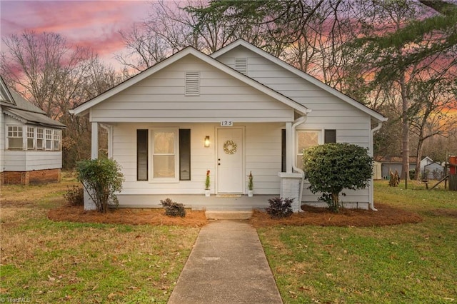 bungalow-style home featuring a yard and covered porch