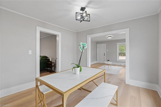 dining room featuring light hardwood / wood-style flooring and ornamental molding