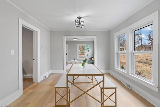 dining area featuring ornamental molding and light wood-type flooring