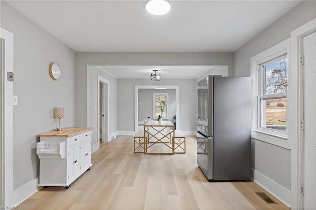 hallway with a healthy amount of sunlight and light hardwood / wood-style floors