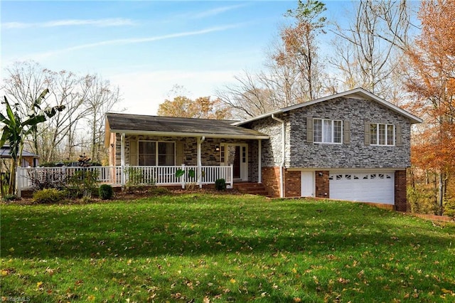 tri-level home featuring covered porch, a garage, and a front yard