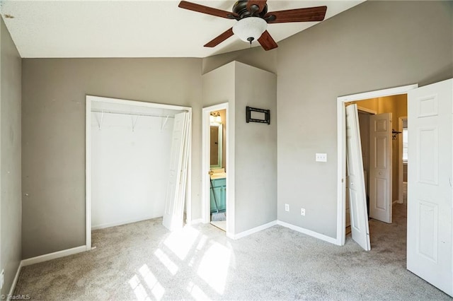 unfurnished bedroom with light carpet, connected bathroom, vaulted ceiling, and a closet