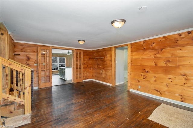 spare room with wood walls, wood-type flooring, and ornamental molding