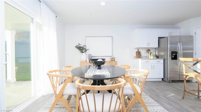 dining space with light hardwood / wood-style flooring and a wealth of natural light